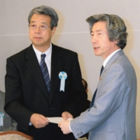 Jiro Ushio (left) hands a list of policy proposals to Prime Minister Junichiro Koizumi at the Prime Minister\'s Office in June 2002. | KYODO