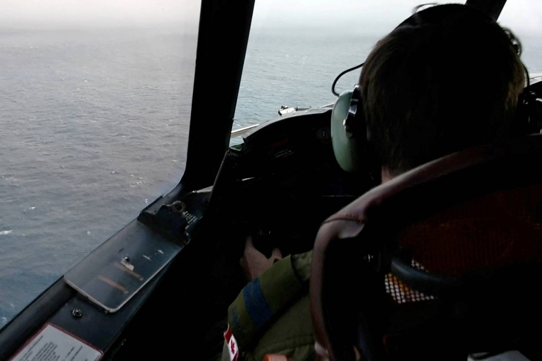 The pilot of a Royal Canadian Air Force CP-140 Aurora maritime surveillance aircraft of 14 Wing flies a search pattern for the missing OceanGate submersible, which had been carrying five people to explore the wreck of the sunken SS Titanic, in the Atlantic Ocean off Newfoundland, Canada, on Tuesday. | CANADIAN FORCES / VIA REUTERS 