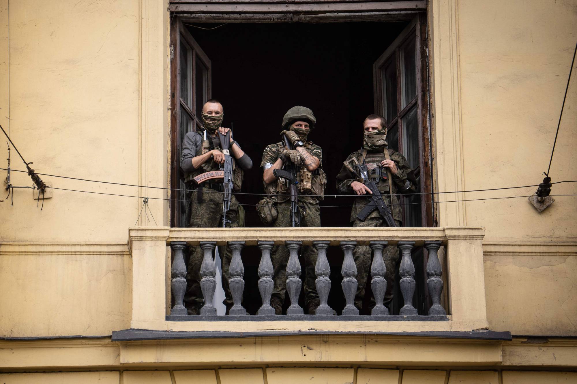 Wagner Group members stand on the balcony of a building in the city of Rostov-on-Don, Russia, on Saturday. | AFP-JIJI
