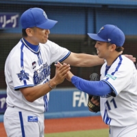 Katsuki Azuma (left) struck out nine batters in his complete-game victory over the Tigers in Yokohama on Saturday. | KYODO