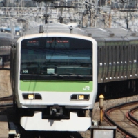 Reports of a man holding a knife on a Yamanote Line train led a crowd passengers to evacuate in a panic on Sunday. | BLOOMBERG 