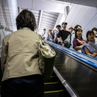 People ride on an escalator at Shinjuku Station in Tokyo on June 1. | AFP-JIJI