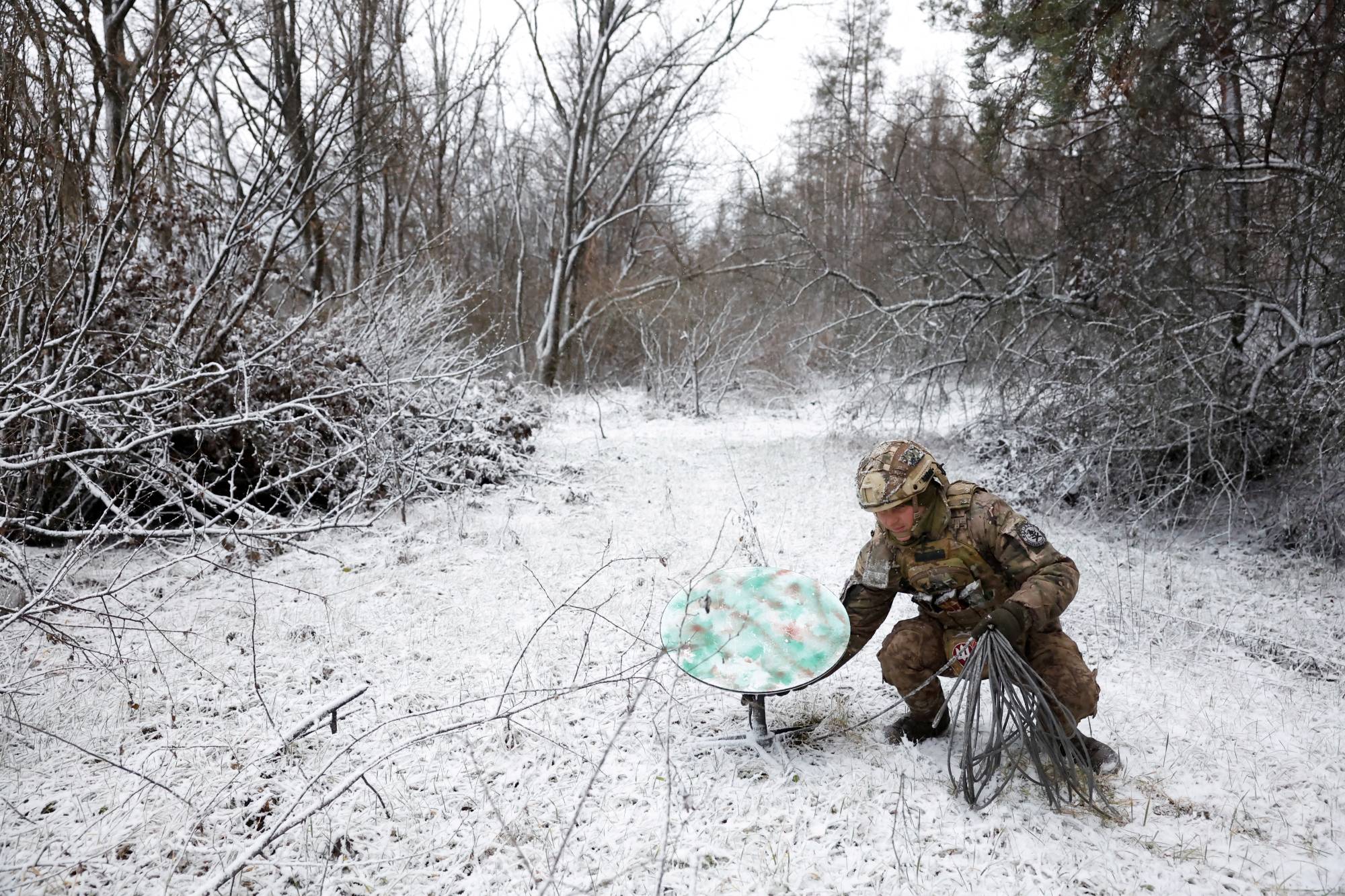 A Ukrainian soldier disconnects a Starlink terminal in the front-line region of Kreminna, Ukraine, in January. | REUTERS