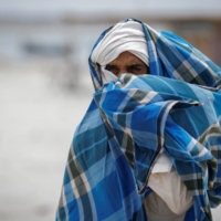 A man covers his face with a scarf in Uttar Pradesh, India, on Wednesday. | REUTERS