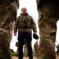 British Defense Secretary Ben Wallace meets the crew of an Ajax Ares armored personnel carrier, to view Ukrainian soldiers training on Challenger 2 tanks, during a visit to Bovington Camp, a British military base in Dorset, England, in February. |  POOL / VIA REUTERS