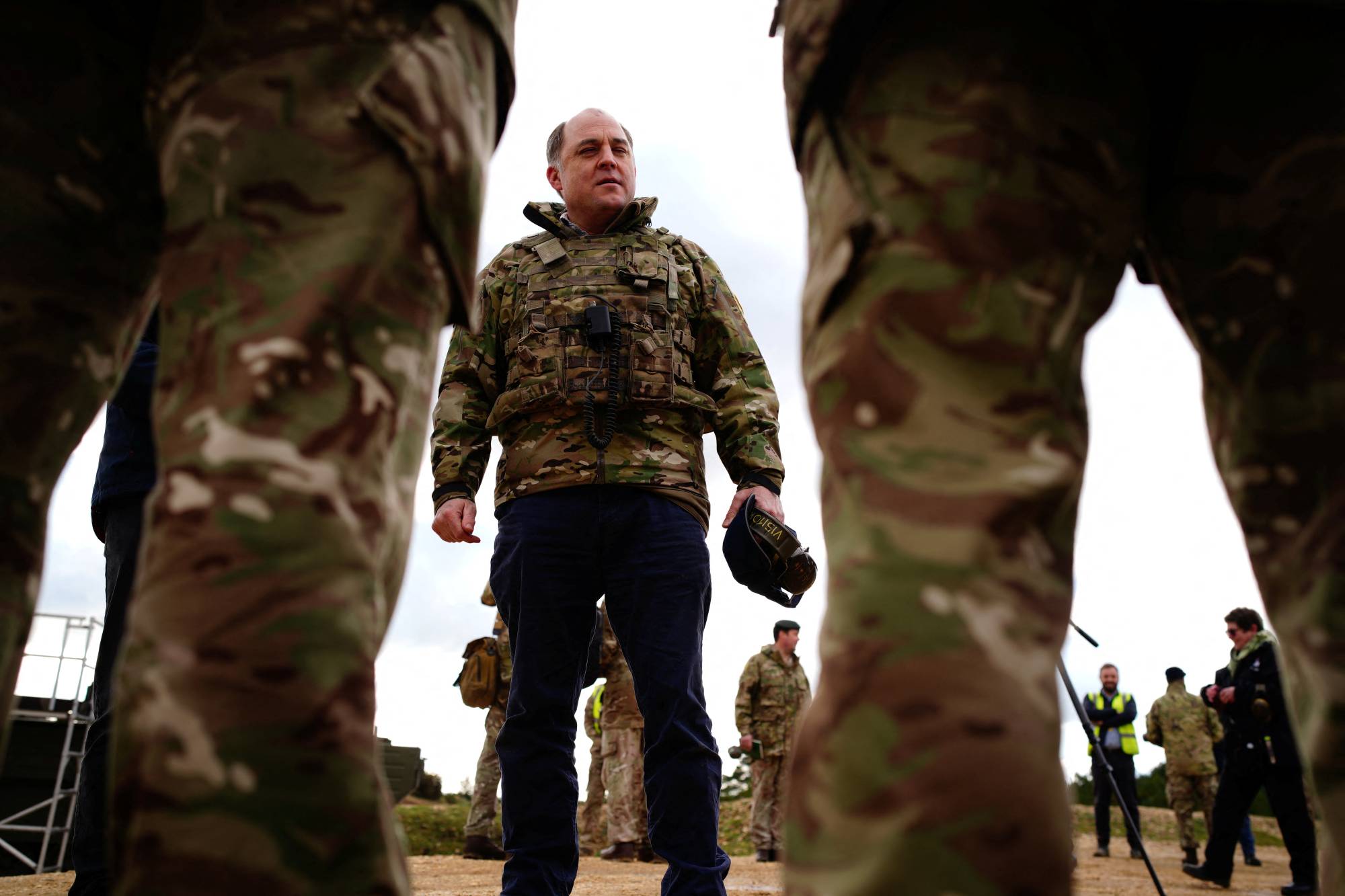British Defense Secretary Ben Wallace meets the crew of an Ajax Ares armored personnel carrier, to view Ukrainian soldiers training on Challenger 2 tanks, during a visit to Bovington Camp, a British military base in Dorset, England, in February. | Pool / via REUTERS