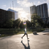 An early-morning exerciser runs along Lady Bird Lake in Austin, Texas, on Tuesday. | MATTHEW BUSCH / THE NEW YORK TIMES

