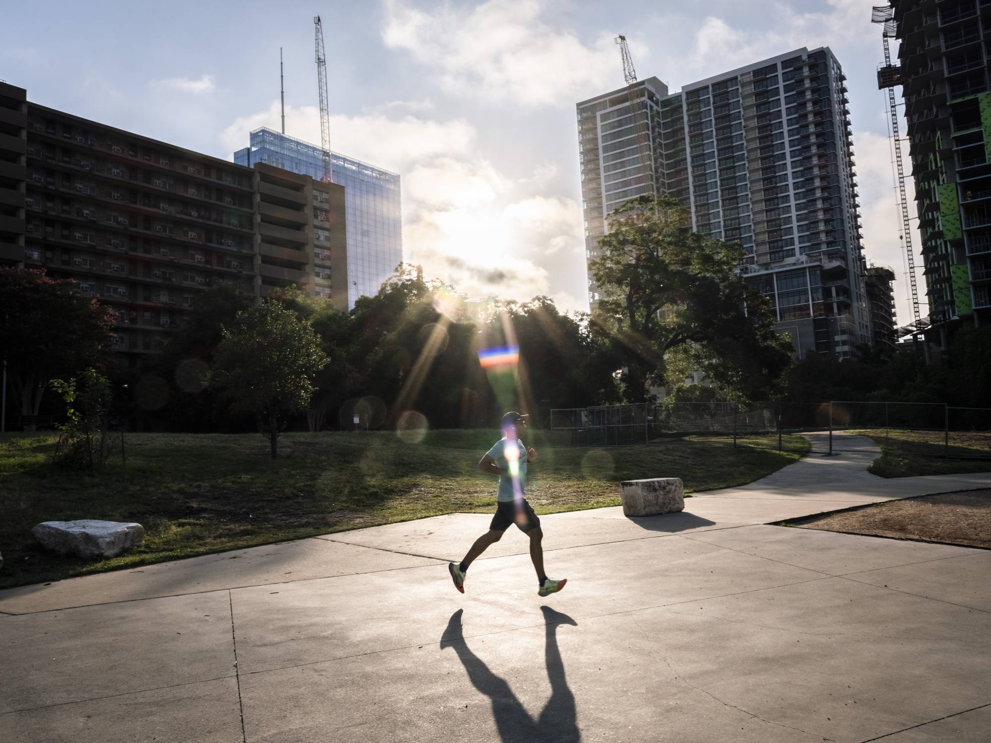 An early-morning exerciser runs along Lady Bird Lake in Austin, Texas, on Tuesday. | Matthew Busch / The New York Times 
