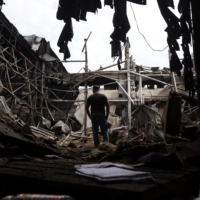 A man walks among debris in a damaged warehouse after a strike in Odesa, Ukraine, on June 14.  | GETTY IMAGES / AFP-JIJI