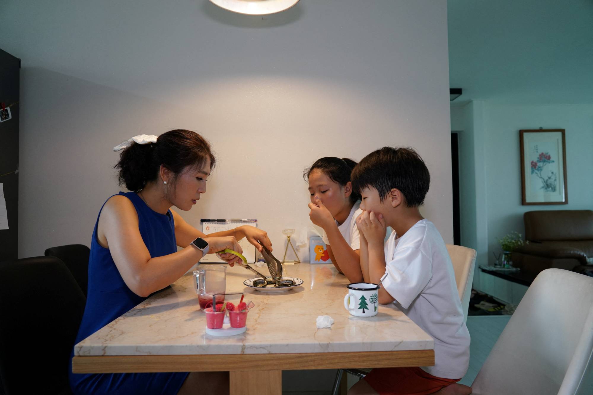 Lee Young-min, 38, has a seafood meal with her children at her house in Seongnam, South Korea, on Wednesday | REUTERS