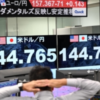 Electronic quotation boards display the rate of the yen versus the U.S. dollar at a foreign exchange brokerage in Tokyo on Friday. | AFP-JIJI

