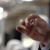 This video grab from an online Neuralink livestream shows Elon Musk holding the the company\'s brain implant during a presentation in August 2020. The device just got approval for testing by U.S. regulators | NEURALINK / VIA AFP-JIJI 