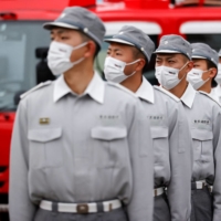 Tokyo Fire Department ambulance unit personnel take part in a review in January 2022. | REUTERS