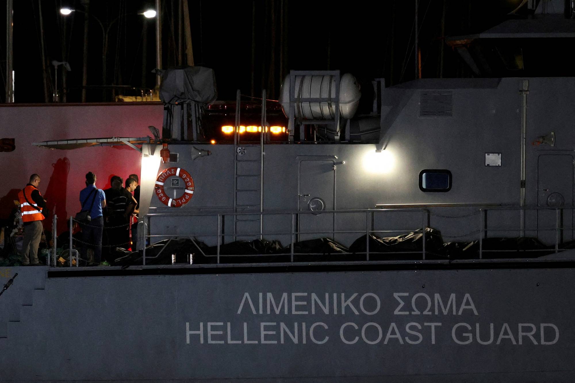 Body bags carrying migrants who died after their boat capsized in the open sea off Greece at the port of Kalamata, Greece, on June 14. | REUTERS