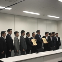 Working-group chairman Itsunori Onodera and deputy chairman Shigeki Sato submit the proposal respectively to the LDP and Komeito policy chiefs in parliament on Wednesday. | GABRIELE NINIVAGGI
