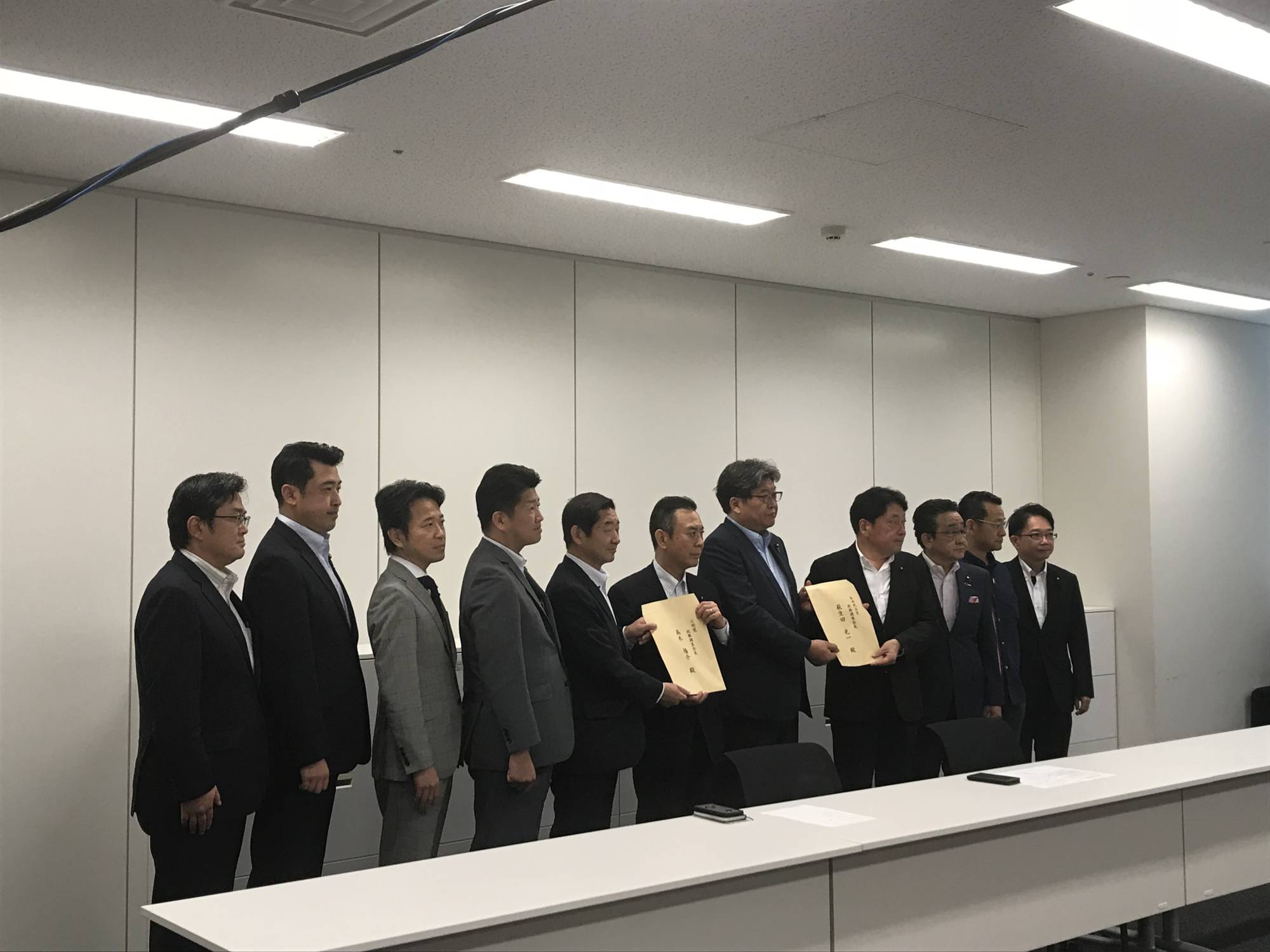 Working-group chairman Itsunori Onodera and deputy chairman Shigeki Sato submit the proposal respectively to the LDP and Komeito policy chiefs in parliament on Wednesday. | Gabriele Ninivaggi 