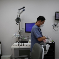 Pediatrician Song Jong-geun gets ready at his clinic in Seoul on June 14. | REUTERS
