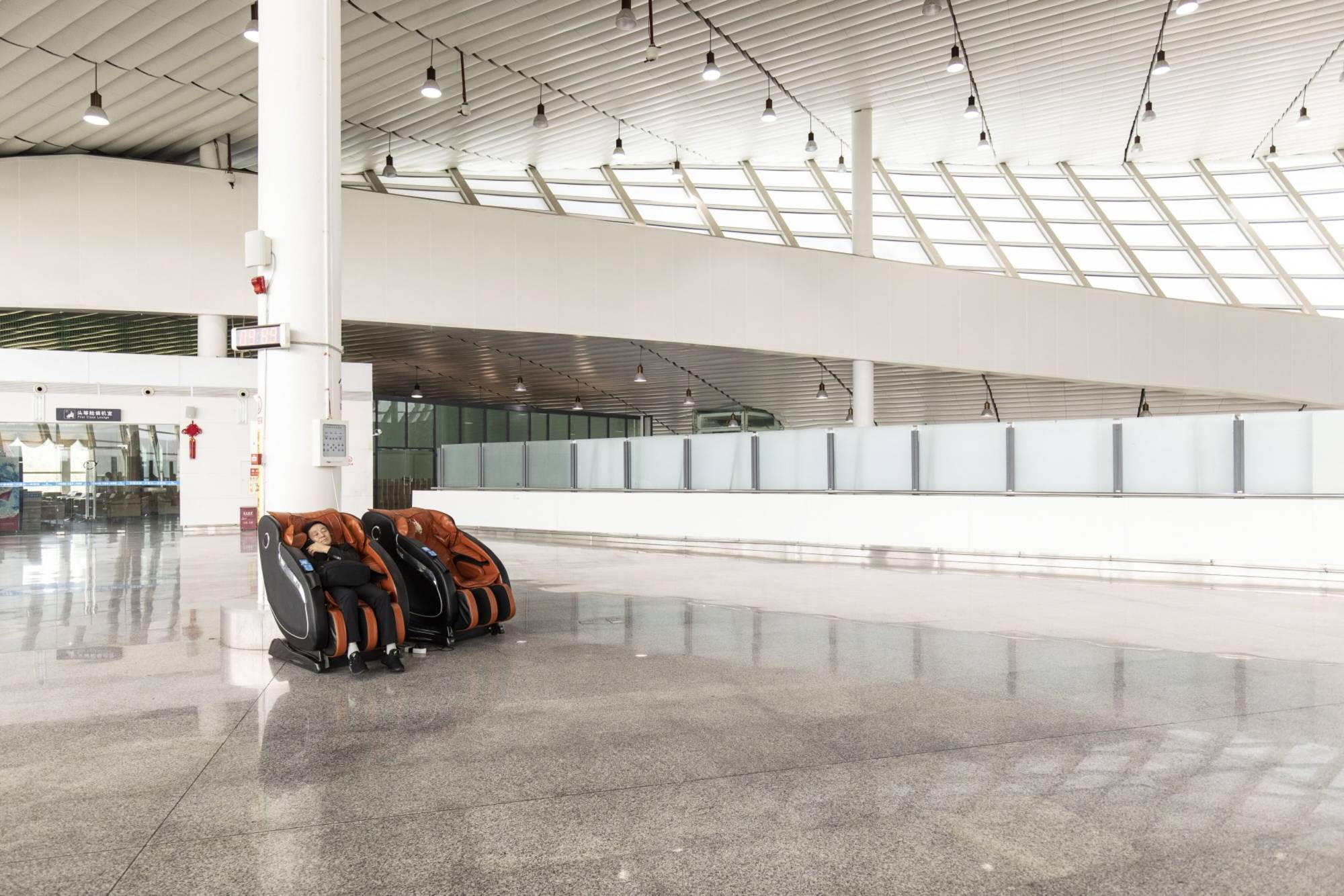 A passenger waits for a flight at Yuezhao Airport — which now only has one flight a day, 4 days out of the week — in Guizhou province, China, on June 16. | BLOOMBERG