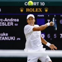 Yosuke Watanuki hits a return against Marc-Andrea Huesler during their match at Wimbledon in London Thursday. | KYODO