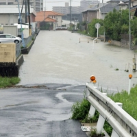 A flooded road in Matsune, Shimane Prefecture, on Saturday | KYODO
