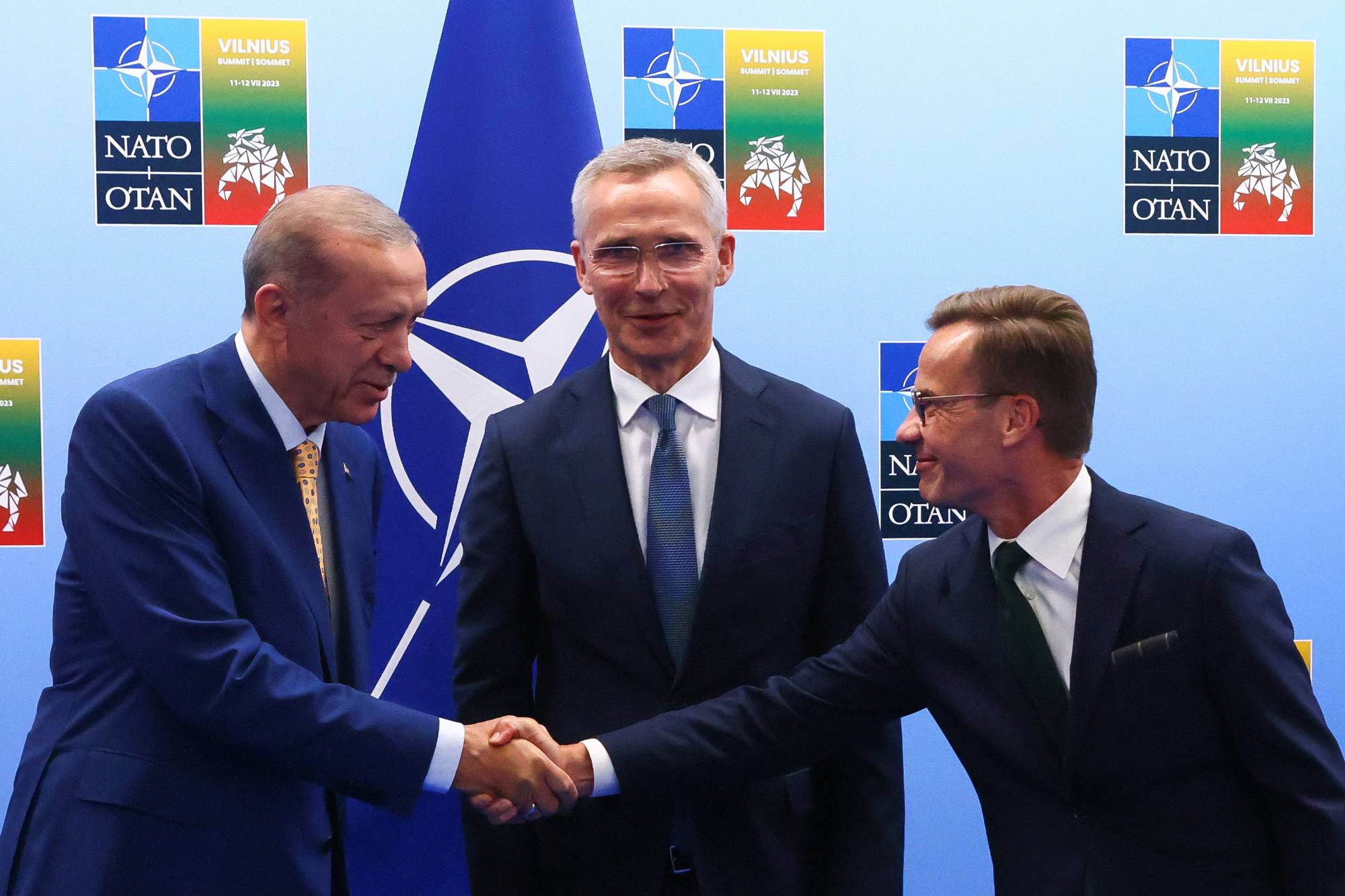 Turkish President Recep Tayyip Erdogan and Swedish Prime Minister Ulf Kristersson shake hands next to NATO Secretary-General Jens Stoltenberg prior to their meeting, on the eve of a NATO summit, in Vilnius, Lithuania, on Monday. | POOL / VIA REUTERS