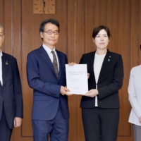 Kimi Onoda (second from right), parliamentary vice minister of defense, receives a report from an expert panel on Wednesday at the Defense Ministry in Tokyo. | KYODO