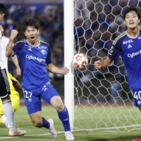 Machida\'s Yu Hirakawa (center) celebrates after scoring against Marinos during their Emperor\'s Cup match in Machida, western Tokyo, on Wednesday. | KYODO