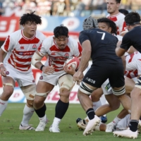 Japan XV captain Kazuki Himeno (second from left) attacks the New Zealand XV end during an international friendly in Kumamoto on Saturday. | KYODO