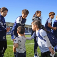 Nadeshiko Japan players greet children following a practice session in Christchurch, New Zealand, on Monday. | KYODO