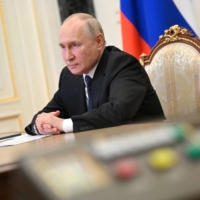 Russian President Vladimir Putin attends a televised meeting with officials to assess the consequences of an attack on the Crimean Bridge, in Moscow on Monday. | SPUTNIK / KREMLIN VIA REUTERS 