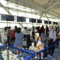 International passengers check in at Terminal 2 at Tokyo\'s Haneda Airport on Wednesday. | KYODO
