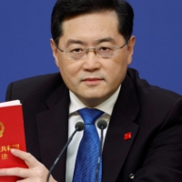 Chinese Foreign Minister Qin Gang holds China\'s Constitution at a news conference on the sidelines of the National People\'s Congress in Beijing in March. | REUTERS