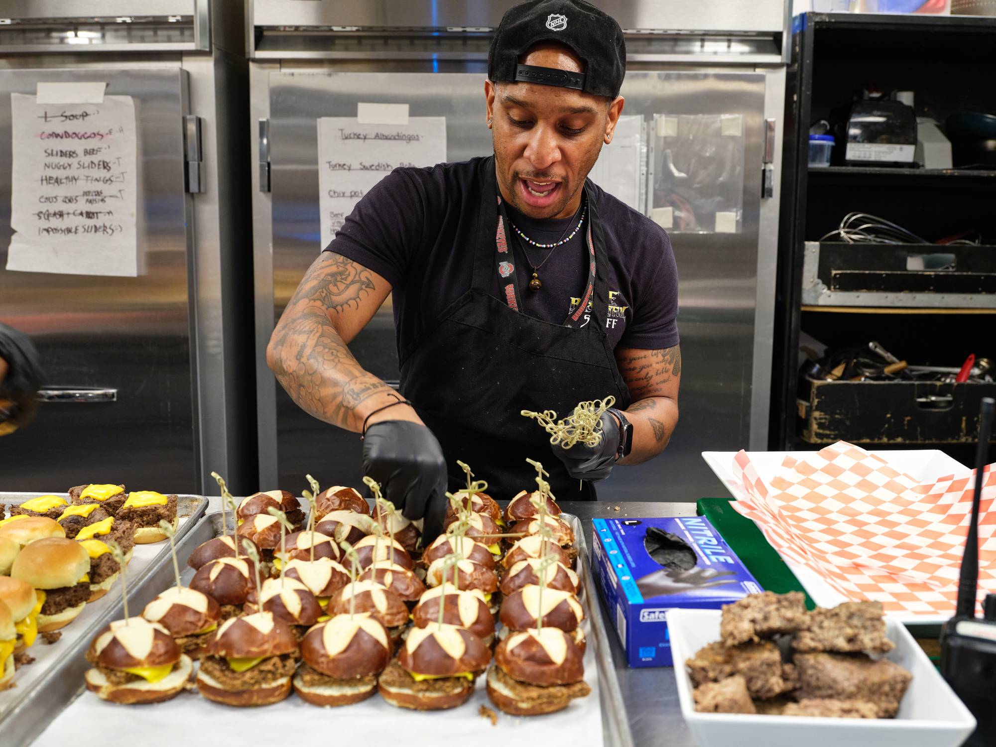 Jacob Curry puts some finishing touches on a sandwich spread at a Lizzo show. | MICHELLE GROSKOPF / THE NEW YORK TIMES