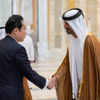 Prime Minister Fumio Kishida is greeted by Abdulla bin Touq Al Mari, the UAE\'s minister of economy, during a reception in Abu Dhabi, United Arab Emirates, on Monday.  | UAE PRESIDENTIAL COURT / VIA REUTERS 