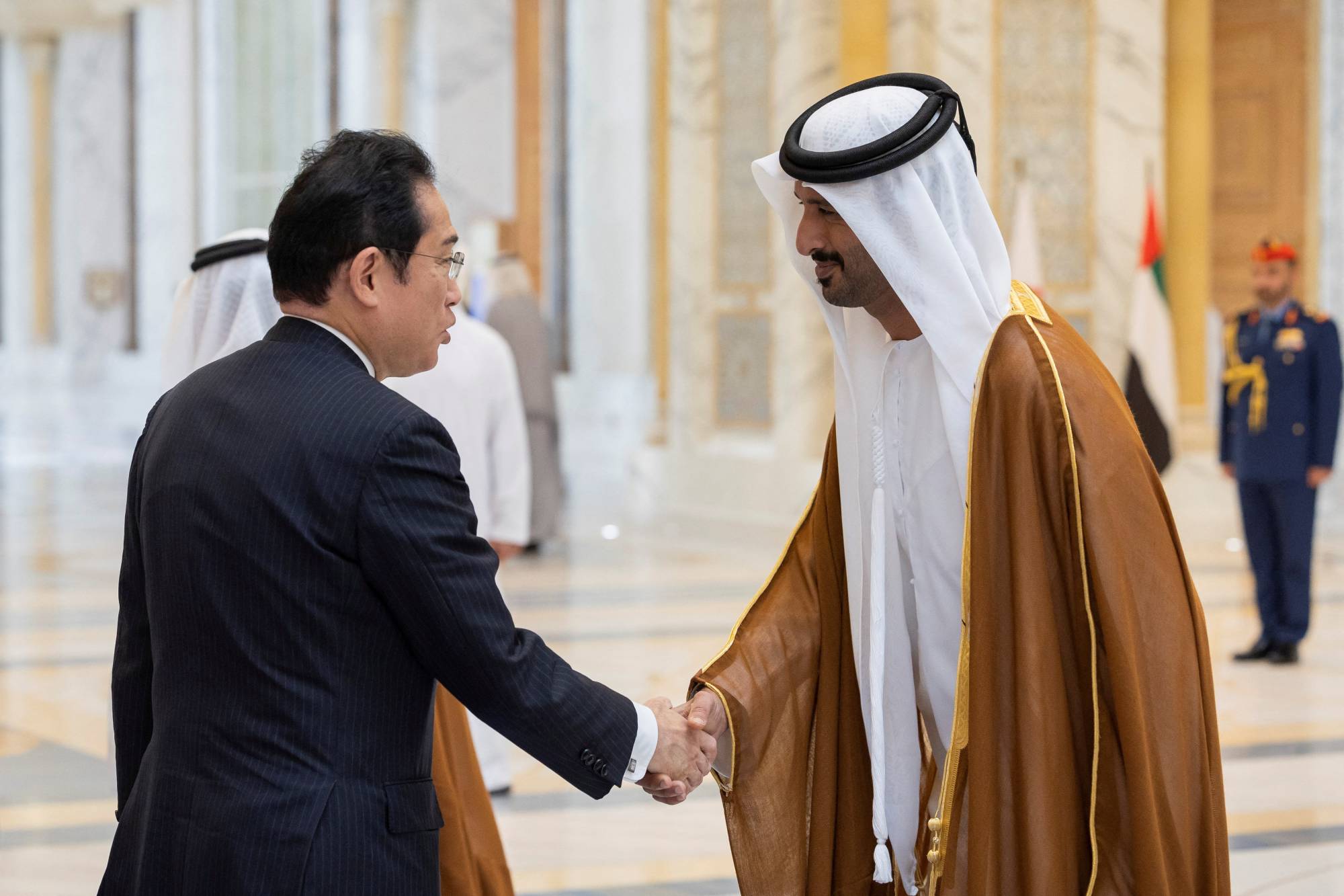 Prime Minister Fumio Kishida is greeted by Abdulla bin Touq Al Mari, the UAE's minister of economy, during a reception in Abu Dhabi, United Arab Emirates, on Monday.  | UAE PRESIDENTIAL COURT / VIA REUTERS 