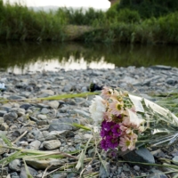 Flowers on a river bank near where three elementary school girls died Friday in Miyawaka, Fukuoka Prefecture. | KYODO 