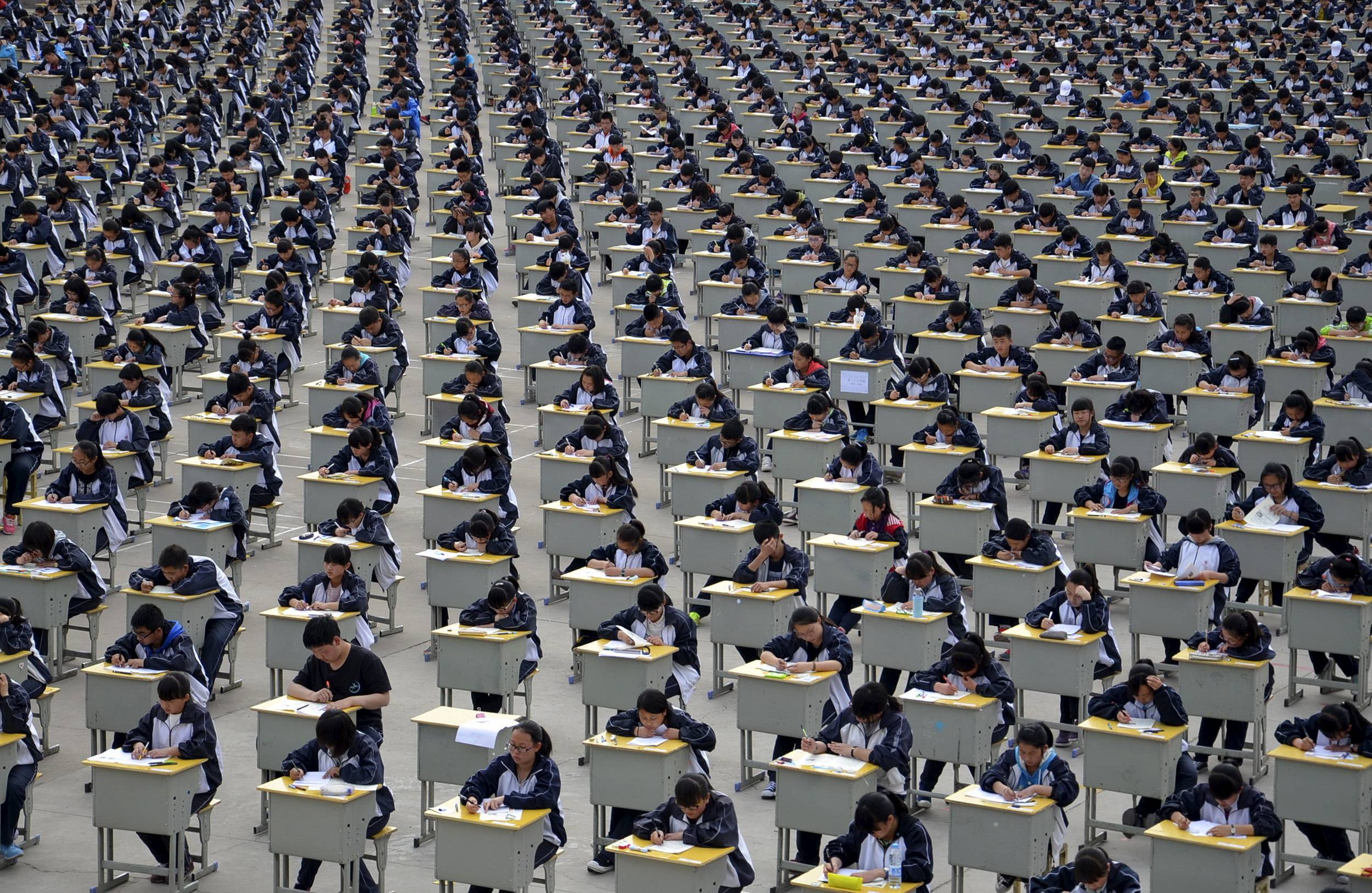 Students take an examination outdoors at a high school in Yichuan, China, in 2015.   | REUTERS