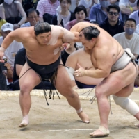 Hakuoho (left) battles through an attack by Hokutofuji during their bout in Nagoya on Saturday.  | KYODO 