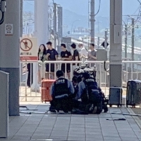 A photo supplied by a passenger shows police officers taking down a stabbing suspect on a platform of Rinku Town Station in Izumisano, Osaka Prefecture, on Sunday. | KYODO