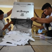 Cambodian election officials prepare to count ballots at a polling station in Phnom Penh on Sunday.   | AFP-JIJI
