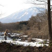 The joys of nature: An old gent casts a line into the Torii River, with Kurohime mountain as a magnificent backdrop. For safety\'s sake, perhaps he too should be banned from playing by the river as our local elementary school children now are. | (C) JOZENJI STREETJAZZ FESTIVAL PLANNING COMMITTEE