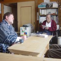 Honored guest: C.W. Nicol with Ainu leader Shigeru Kayano at his home in Nibutani, Hokkaido, on Jan. 17, 2006, after being presented with this embroidered Ainu kimono. | NATSUYO SEARLE PHOTO