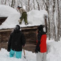 Many hands: My three Australian visitors make light work of clearing the sauna\'s roof. | MARK BRAZIL PHOTOS