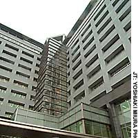 Outside the imposing new building that houses the Tokyo Regional Immigration Bureau in Minato Ward (above), which opened in February, and inspecting the facilities inside. | AP PHOTO