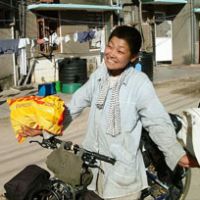 Fancy meeting you here: Yamasaki, surprised by an acquaintance who happened upon her in Dar es Salaam, poses for the camera at the start of her bicycle tour through Africa in late 2004 | COURTESY OF MIO YAMASAKI