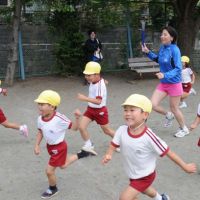 Children at the nursery school race around the park with World Harmony Run volunteer Baast Burmaa. | SATOKO KAWSAKI PHOTOS