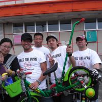 The power of pedals: A mother carrying her 5-month-old baby receives a children\'s bicycle from members of the group Bikes for Japan in Ishinomaki, Miyagi Prefecture, in late April. | BIKES FOR JAPAN