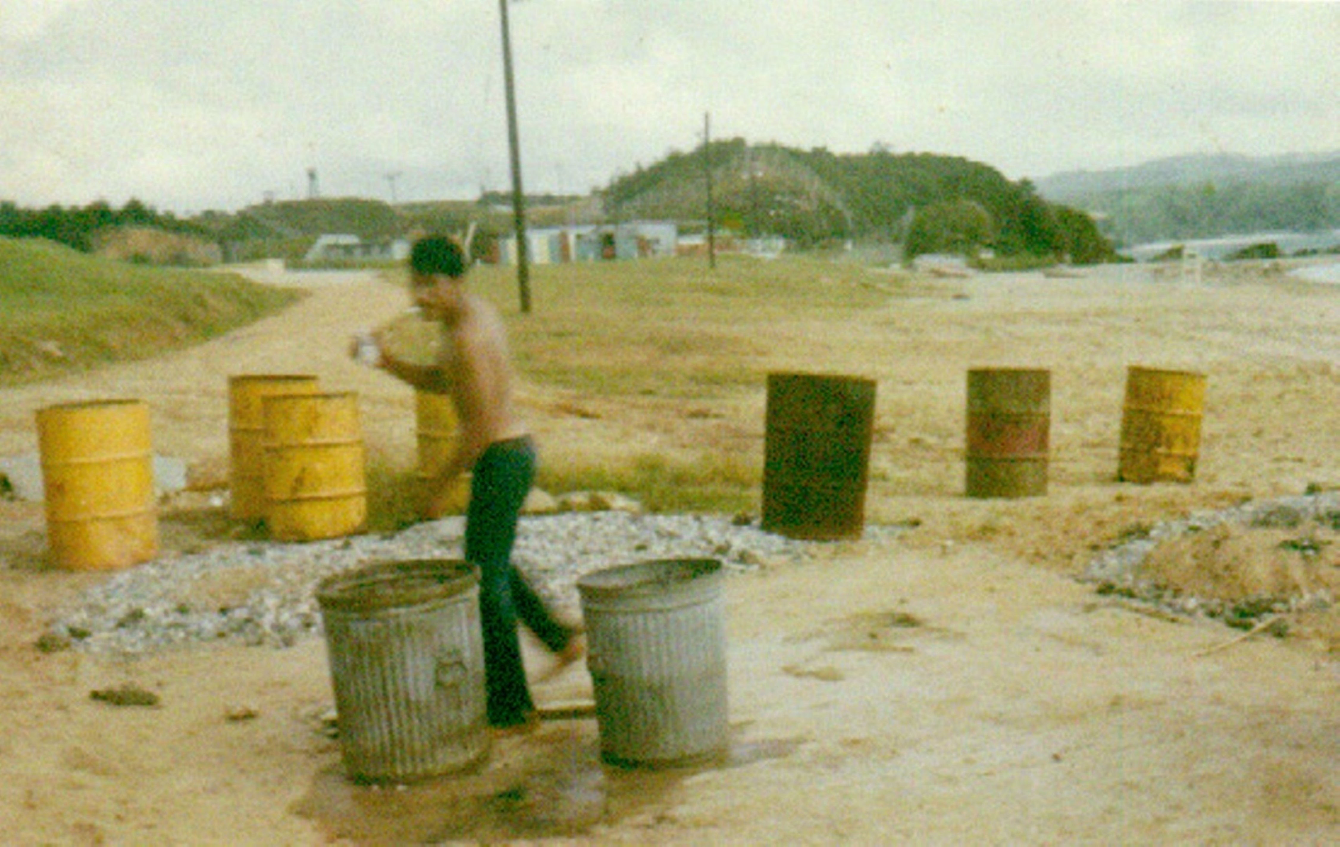 U.S. Marine Scott Parton stands among barrels including one, second from right, that he says contained Agent Orange, at Camp Schwab in 1971. | COURTESY OF SCOTT PARTON