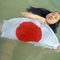 In one of Ishikawa\'s recent works, drama school student Wakana Oshiro gives her interpretation of the Hinomaru flag. | STEVE TRAUTLEIN