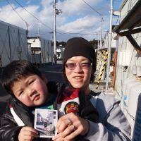 Memory bank: Proud father Tomohiro Nagakura shows off his son, Yushin, and a photo given to him by Photohoku at the Hirobata Temporary Housing Complex in Shinchi, Fukushima Prefecture. | JON MITCHELL PHOTOS